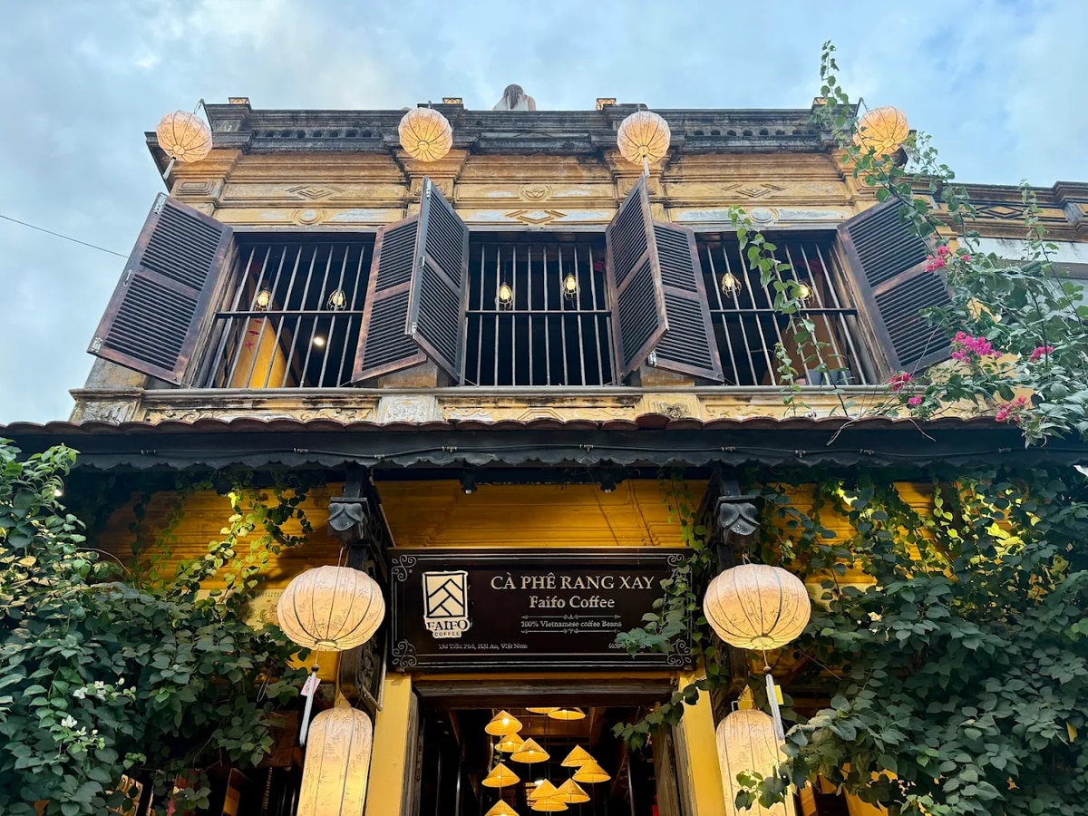 Faifo Coffee nổi bật với tường vàng và cửa sổ gỗ cổ kính mang đậm chất Hội An